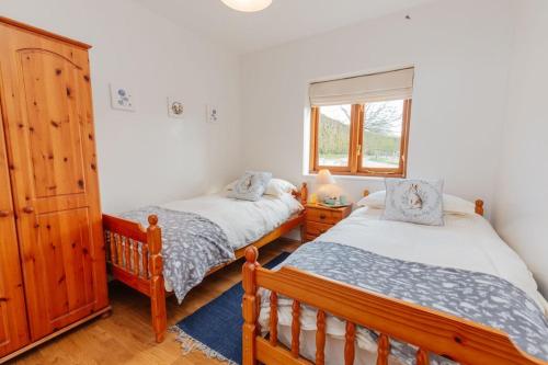 汤顿The Croft @ Warrens Farm的一间卧室设有两张床和窗户。