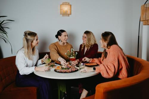 托伦Hotel restaurant SAM的四个坐在餐桌边的女人,拿着一盘食物