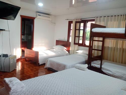 比亚维森西奥Finca Campestre El Encanto的客房设有三张双层床和一台平面电视。