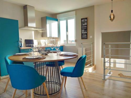 马翁普拉日堡Superbe apt cosy à 500m de la plage pour 4 pers的一间厨房,内设一张桌子和蓝色的椅子