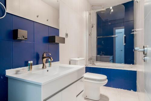 马德里Flamenco Style Apartment PALACIO REAL, La Latina的蓝色和白色的浴室设有水槽和卫生间