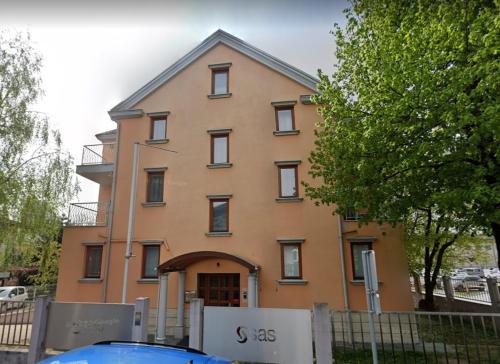 卢布尔雅那Apartments Katrca Bežigrad的一座橙色的大建筑,前面有栅栏