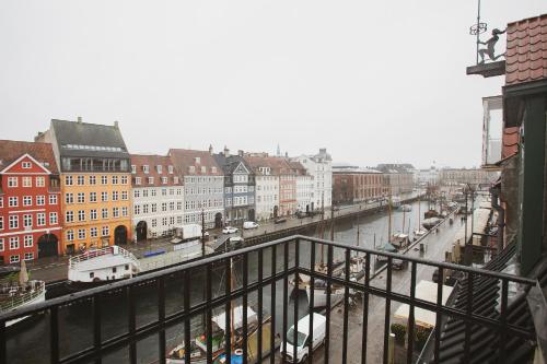 哥本哈根Modern 3BR Duplex Flat in Nyhavn w Private Balcony的享有河流和建筑的城市美景