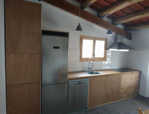 马斯诺apartamento cerca de tren, playa y Barcelona的厨房配有不锈钢冰箱和窗户