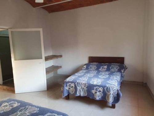 拉佩尼塔德加尔特姆巴C911 Casa 2 niveles y alberca privada的一间卧室配有一张带蓝色和白色床单的床。