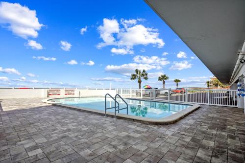 圣徒皮特海滩Sunset Chateau 207的一座拥有蓝天和棕榈树的游泳池