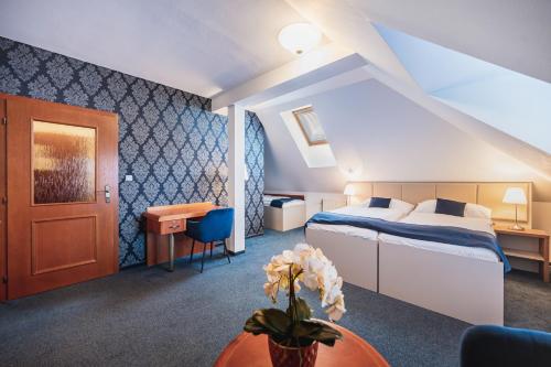 赫拉德茨 - 克拉洛韦乌克拉罗伟伊利斯基酒店的酒店客房配有一张床铺和一张桌子。
