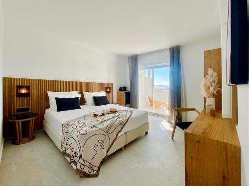 米克诺斯城Calistus Mykonos的一间卧室设有一张床和一个美景窗户。
