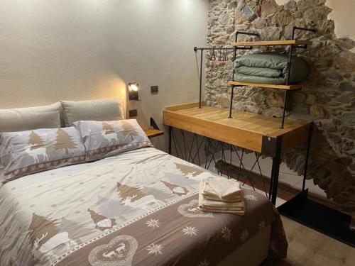 托尔诺Chez Margot et Sophie的一间卧室设有一张床和石墙