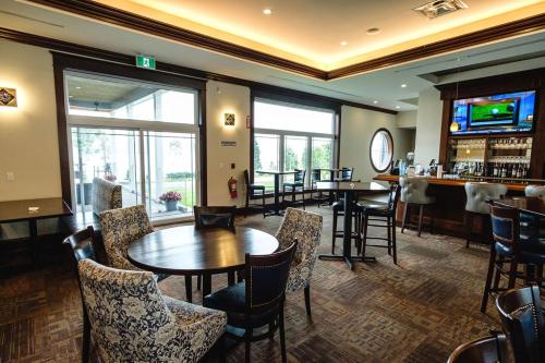 Sydney ForksThe Lakes at Ben Eoin Golf Club & Resort的一间带桌椅的餐厅和一间酒吧