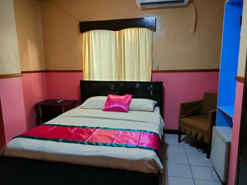 科罗尔LEHNS MOTEL的一间卧室配有一张带粉红色枕头的床