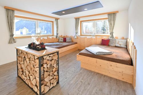 茵特斯托德Hotel Sonnfeld的客房设有两张床和一张带原木的桌子。