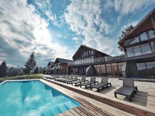 亚布卢尼齐亚SevenHills chalet的一个带长椅的游泳池和一座建筑的度假胜地