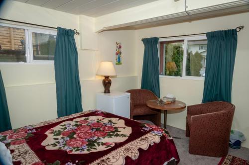 阿伯茨福德Guest Suite Private Retreat- Honeymoon Suite- J-1的一间卧室配有一张床、一张桌子和两个窗户