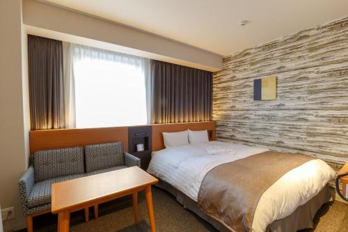 千叶京成米拉玛丽酒店的配有一张床和一把椅子的酒店客房