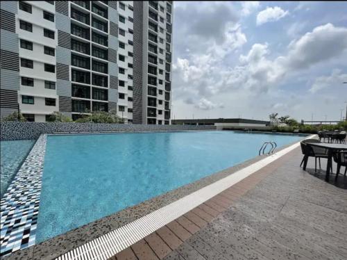迪沙鲁Desaru Dhancell Executive Homestay All Bedrooms With NETFLIX的一个带桌子的游泳池以及一些建筑