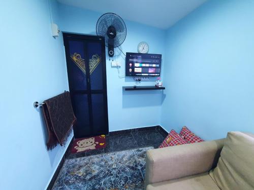 莎阿南Cabin stay with Sunrise and plane spotting view的带沙发和蓝色墙壁的客厅