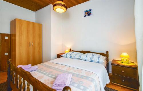 杜基拉特Amazing Apartment In Dugi Rat With Kitchen的一间卧室配有带梳妆台和橱柜的床。