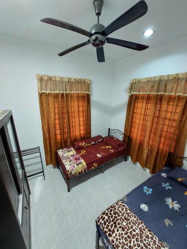 Pasir MasHOMESTAY BONDA PASIR MAS, KELANTAN的一间卧室配有两张床和吊扇