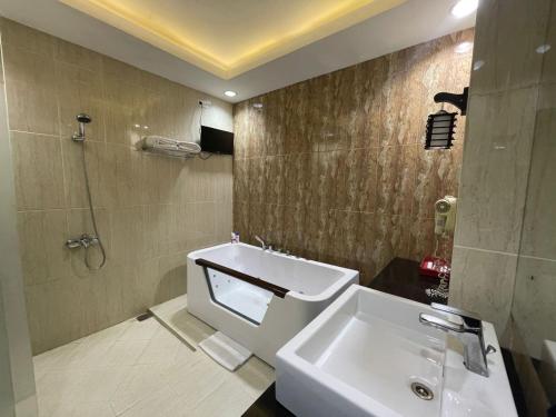 DukuGrand Buana Lestari Hotel的一间带水槽、卫生间和淋浴的浴室
