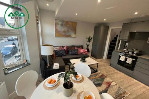 芬奇利Aisiki Apartments at Stanhope Road, North Finchley, a Multiple 2 or 3 Bedroom Pet-Friendly Duplex Flats, King or Twin Beds with Aircon & FREE WIFI的客厅配有两张桌子和一张沙发