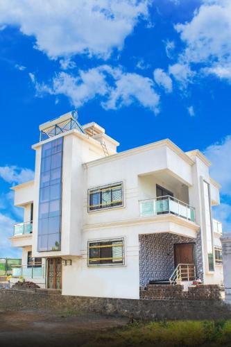 VeshviSukhakarta Holiday Home的蓝色天空的白色房子