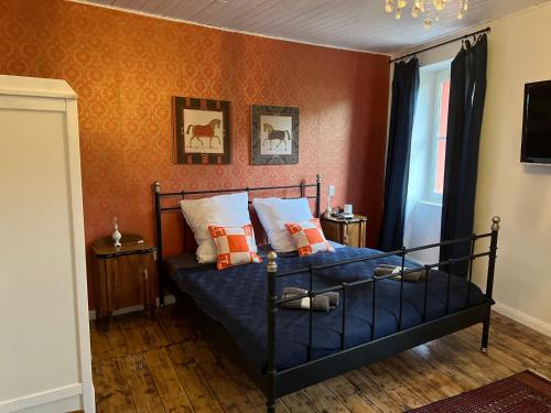 托斯科拉诺-马德尔诺CASA LINDNER Villa Rustico Ferienhaus 400m zum Gardasee 13Schlafplätze的一间卧室配有一张带蓝色床单和橙色墙壁的床。