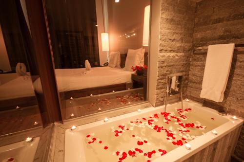 塔那那利佛卢浮宫酒店及spa中心的浴室配有带红色鲜花的浴缸。