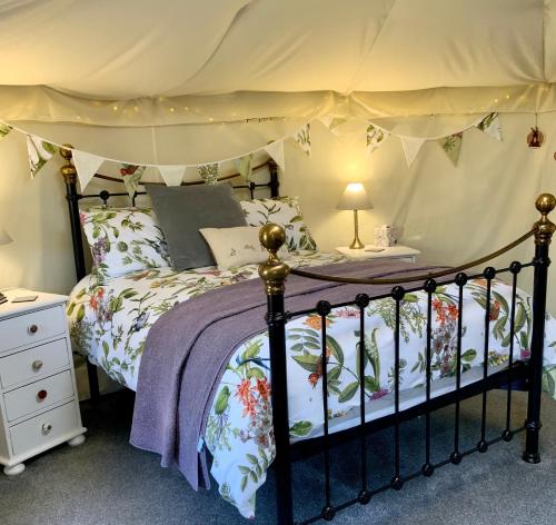 劳斯Bramble Lodge Glamping的一间卧室配有一张带天蓬的床