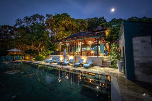 爱妮岛Karuna El Nido Villas的夜间带游泳池的别墅