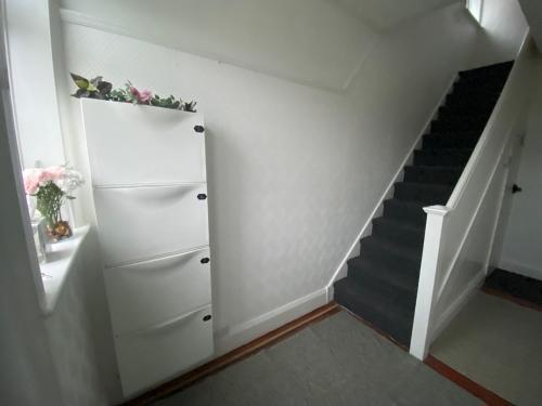 德比Peaceful stay Derby Single Room的一条带白色橱柜和楼梯的楼梯