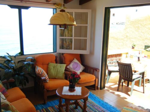 San Juan de la RamblaCasa Rural Virgen del Rosario的客厅配有橙色椅子和桌子