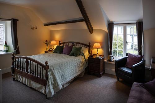 WinsfordThe Royal Oak Exmoor的一间卧室配有一张床、一把椅子和窗户。