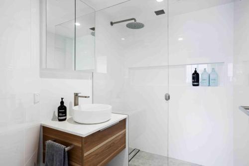 黄金海岸Beachfront Luna Apartment的白色的浴室设有水槽和淋浴。