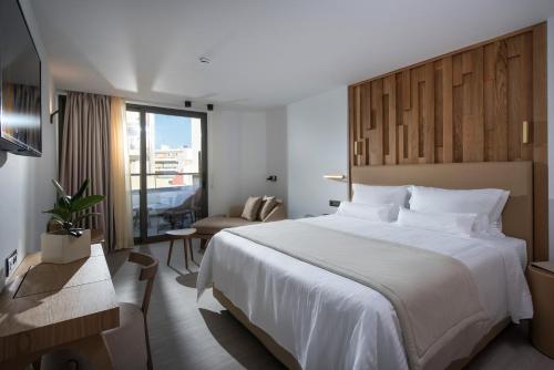 海若克利欧Dimargio Luxury Hotel & Spa的酒店客房带一张大床和一把椅子