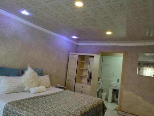 KosterREGYANA BED AND BREAKFAST的一间卧室设有一张床和紫色天花板