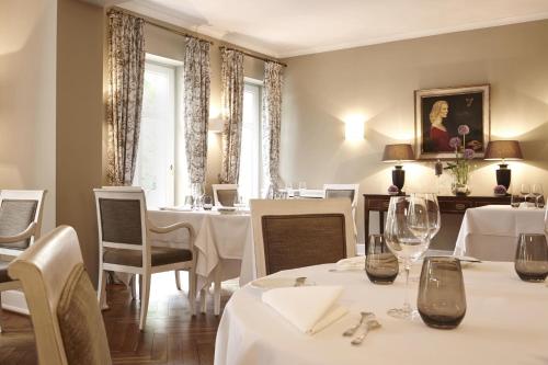 StolpeRelais & Châteaux Gutshaus Stolpe的餐厅设有白色的桌椅和窗户。