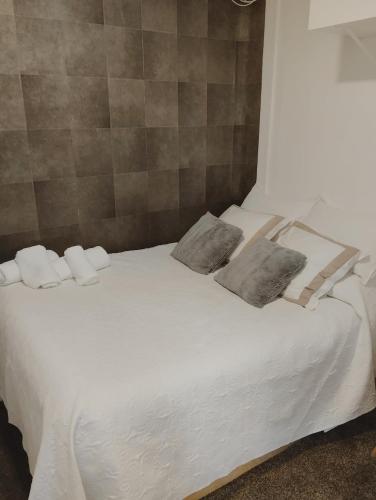 马德里Habitación cerca centro de Madrid的一张白色的床,上面有两个枕头