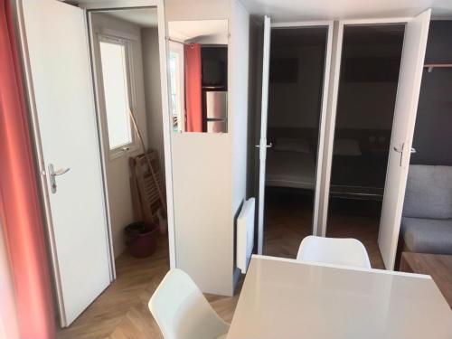 瓦尔拉普拉日MOBIL HOME LE PRECIEUX的一间设有白色桌子和白色椅子的客房