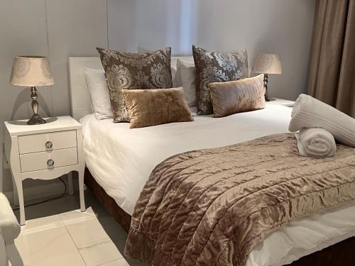 德班Beacon Rock Apartment 208的一间卧室配有一张床和一个带两盏灯的床头柜。