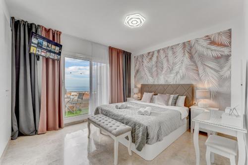 圣地亚哥港Luxury Holiday House Tenerife的一间卧室配有一张床、一张书桌和一个窗户。