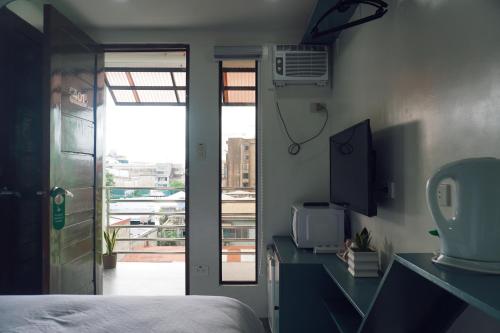 宿务Cebu Backpackers Hostel的一间卧室设有一张床,并有通往阳台的门