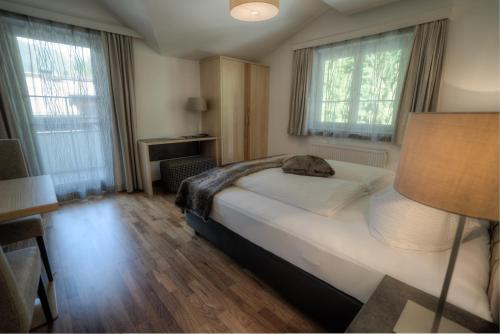 湖城Ferienhaus & Apart Post的一间卧室设有床、两扇窗户和一盏灯。