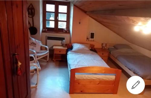 PressinsChambre dans maison a la campagne的阁楼上的卧室配有两张床