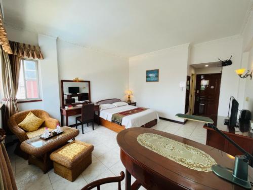 金边Chung Hsin Hotel 中信酒店的酒店客房设有床和客厅。