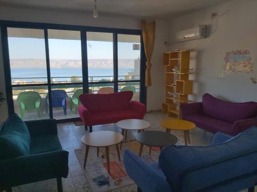提比里亚turtle guesthouse- tiberias的客厅配有色彩缤纷的家具,享有海景。