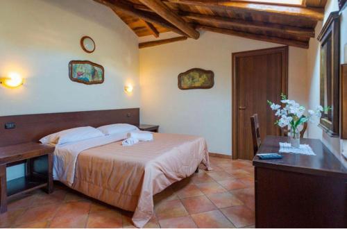 拉加尔纳Villa Casina dell'Etna的一间卧室配有一张床、一张桌子和一张鲜花桌