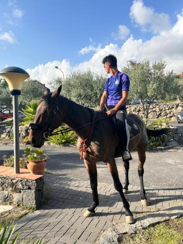 拉加尔纳Villa Casina dell'Etna的骑着马在街上的人
