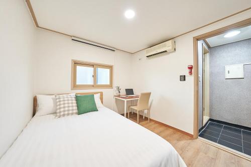 首尔K'STAY Sinchon的卧室配有白色的床和书桌