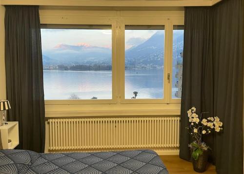 帕拉迪索Alloggio con favolosa vista lago Lugano Paradiso的一间卧室设有大窗户,享有水景